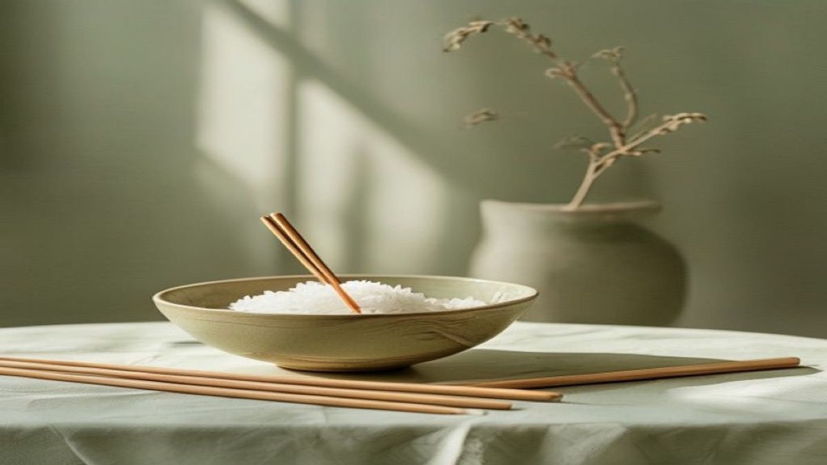 Bát cơm và đôi đũa đặt ngay ngắn trên bàn ăn gỗ giản dị