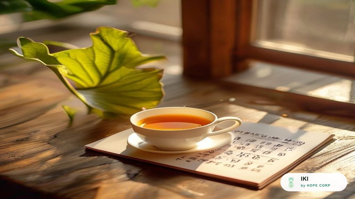Điện thoại cạnh tách trà lá sen và tờ lịch