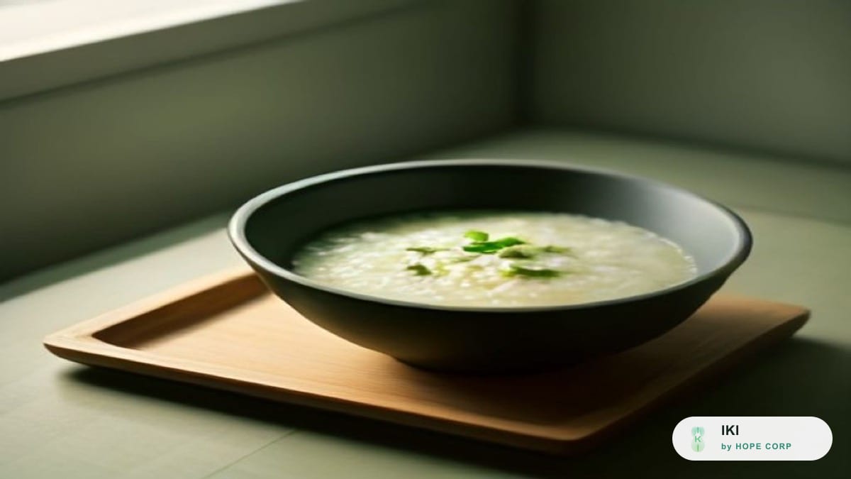 Bát cháo ấm và đĩa rau hấp mềm trên bàn ăn gia đình